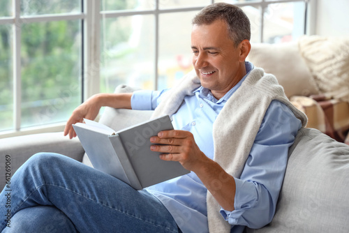 Mature man reading book on ...