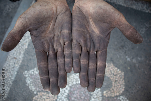 Dirty hands of a man working iron