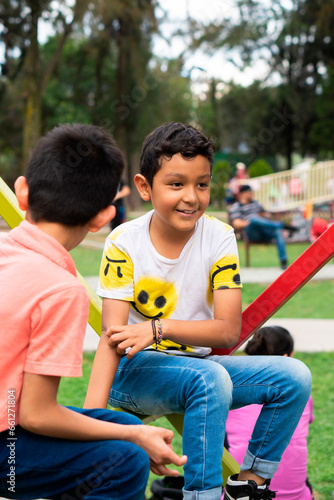 Two children in the park sitting and talking.