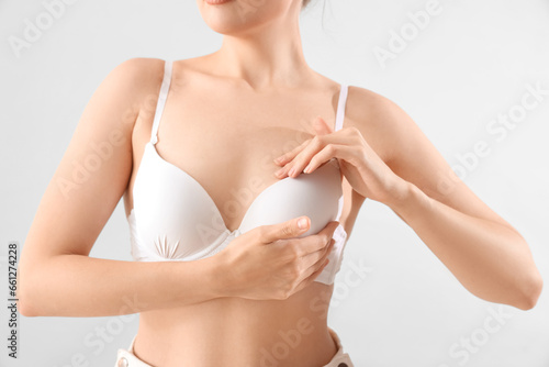 Young woman in bra on light...