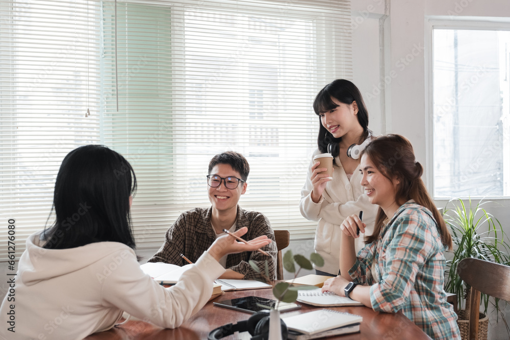 A cheerful and smart young Asian female is standing and sharing her ideas in a meeting with her team. University students, friendship, startups, teamwork A cheerful and smart young Asian female is standing and sharing her ideas in a meeting with her team. University students, friendship, startups, teamwork
