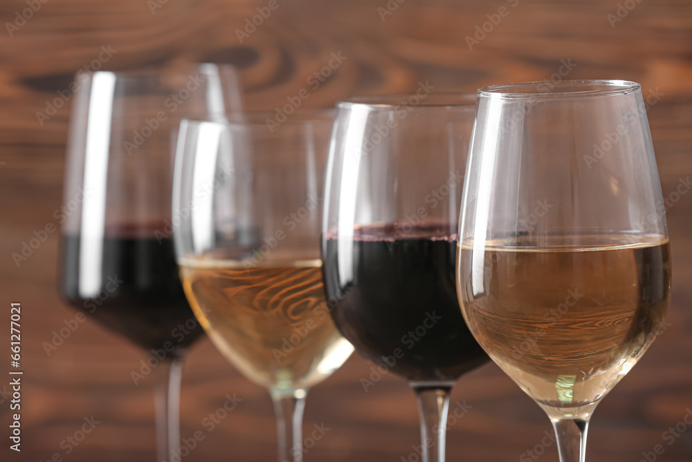 Glasses of different exquisite wine on color background, closeup