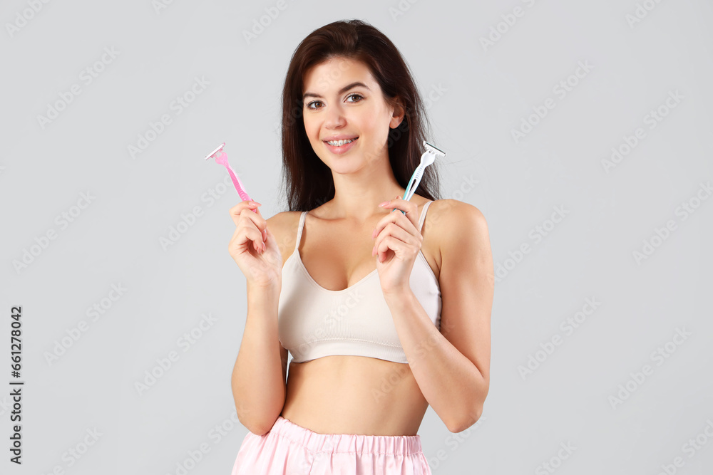 Beautiful woman with razors on light background Beautiful woman with razors on light background