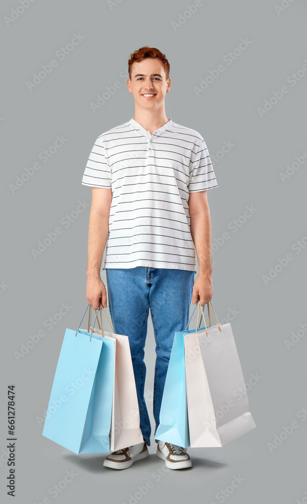 Young man with shopping bags on light background Young man with shopping bags on light background