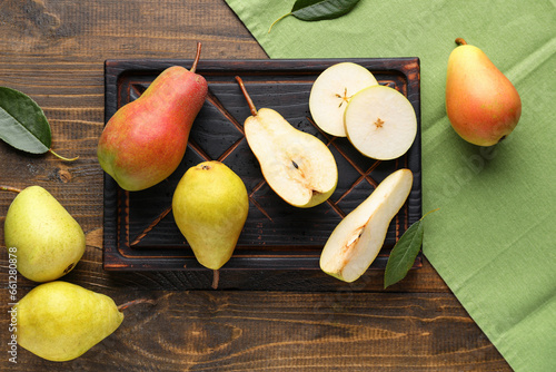 Board with ripe pears on wooden background
