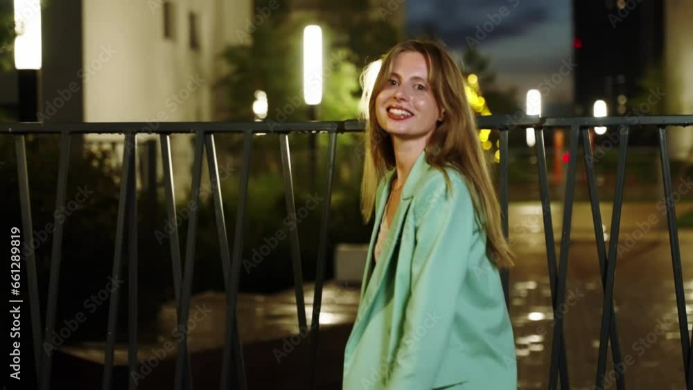 Positive girl spinning around in herself and posing for the camera. Night city with glowing lanterns. Positive girl spinning around in herself and posing for the camera. Night city with glowing lanterns.