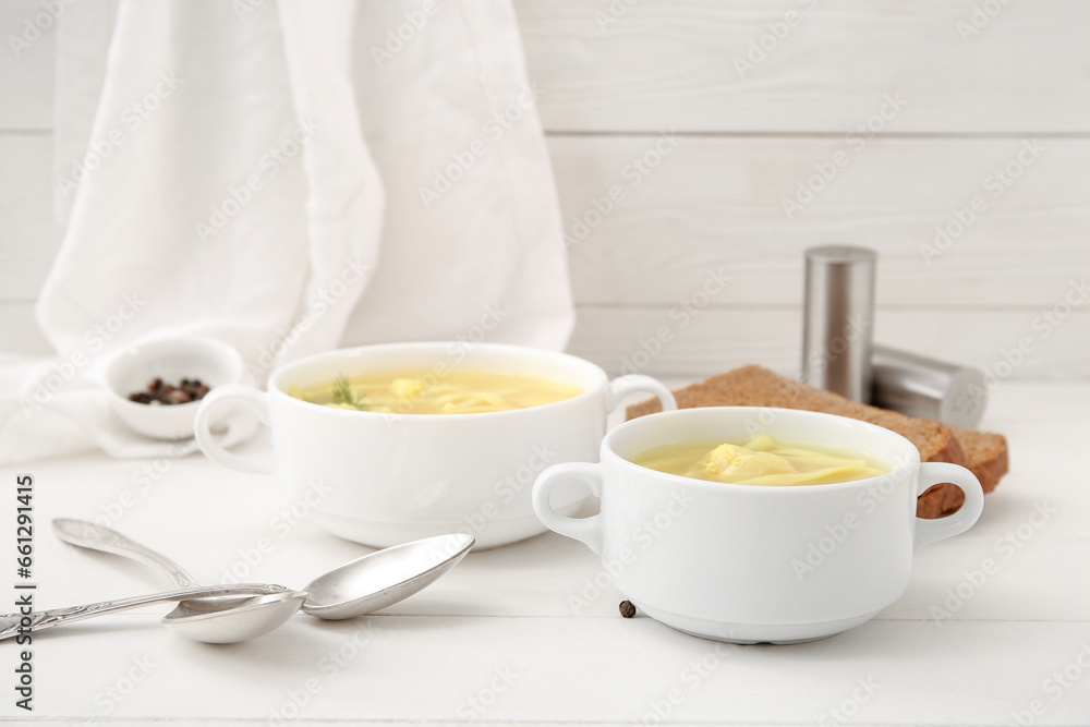 Pots of tasty chicken soup on white wooden background Pots of tasty chicken soup on white wooden background