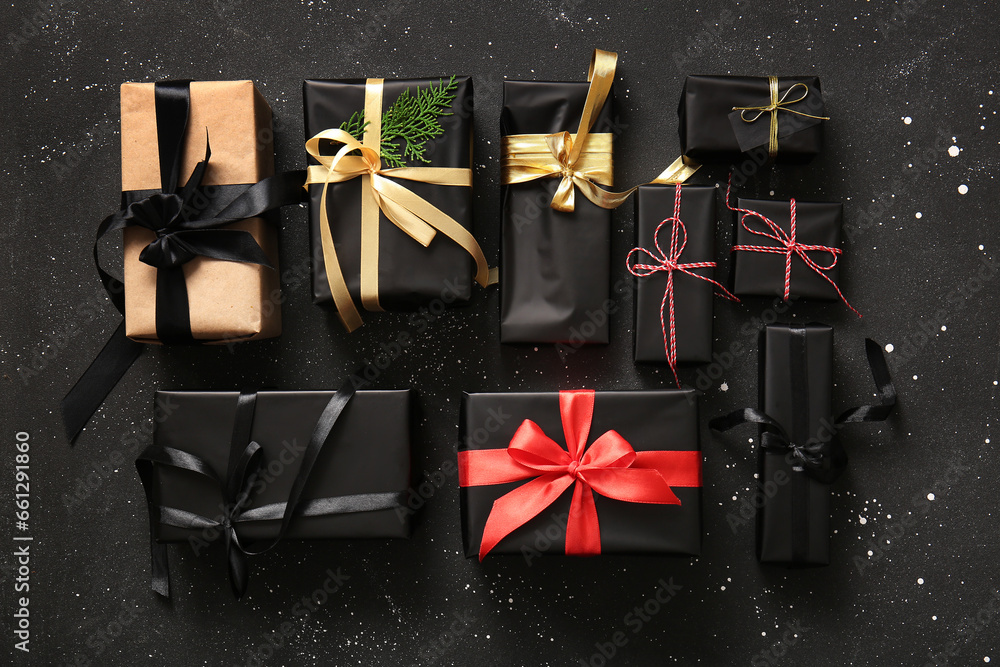 Many Christmas gift boxes with coniferous branch on black background