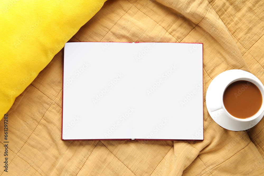 Blank open book and cup of coffee on plaid Blank open book and cup of coffee on plaid