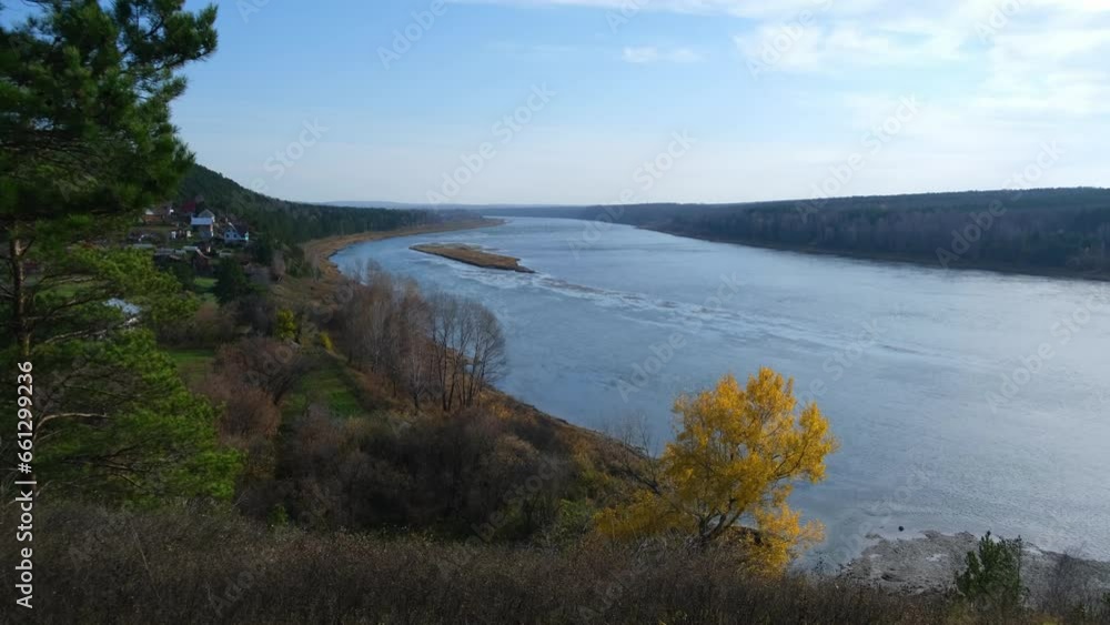 Beautiful, wide autumn river among forests and rocky shore. A calm and quiet place with autumn colors. Reflection of clouds in the water in good weather Beautiful, wide autumn river among forests and rocky shore. A calm and quiet place with autumn colors. Reflection of clouds in the water in good weather