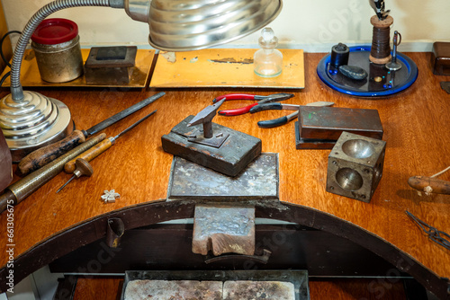 Craft workplace of a jeweler. Jewelry tools and equipment on a goldsmith wooden desk table.