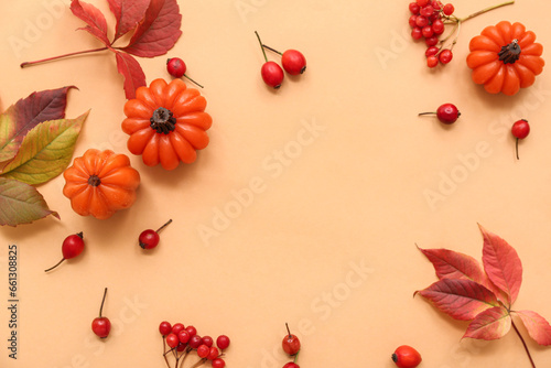 Frame made of candles in shape of pumpkin and autumn leaves on beige background