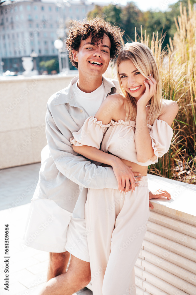 Portrait of young smiling beautiful woman and her handsome boyfriend in casual summer clothes. Happy cheerful family. Female having fun. Couple posing in the street background at sunny day Portrait of young smiling beautiful woman and her handsome boyfriend in casual summer clothes. Happy cheerful family. Female having fun. Couple posing in the street background at sunny day