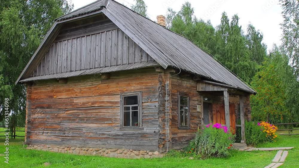 Beautiful old village house made of logs. Flowerbed with flowers in summer. Rest in the countryside, architecture Beautiful old village house made of logs. Flowerbed with flowers in summer. Rest in the countryside, architecture