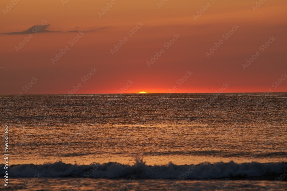 Radiant Sunset Over the Ocean. The Glowing Sun Sinking on the Horizon