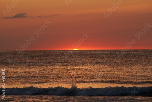 Radiant Sunset Over the Ocean. The Glowing Sun Sinking on the Horizon