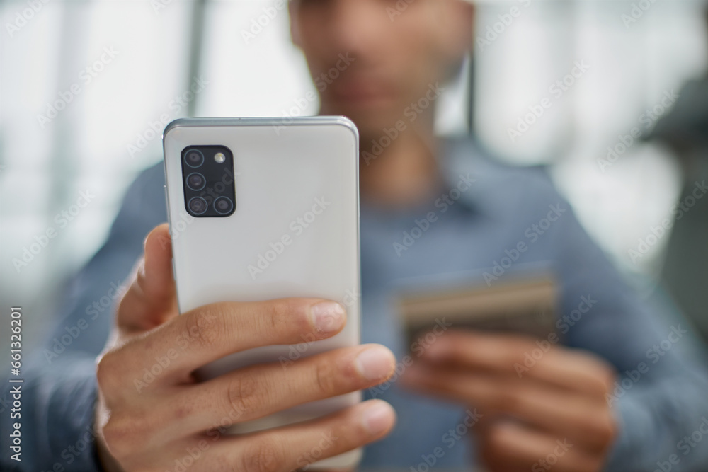 man selects a credit card from several and enters it number into a smartphone to pay online. Online shopping, lifestyle technology. man selects a credit card from several and enters it number into a smartphone to pay online. Online shopping, lifestyle technology.