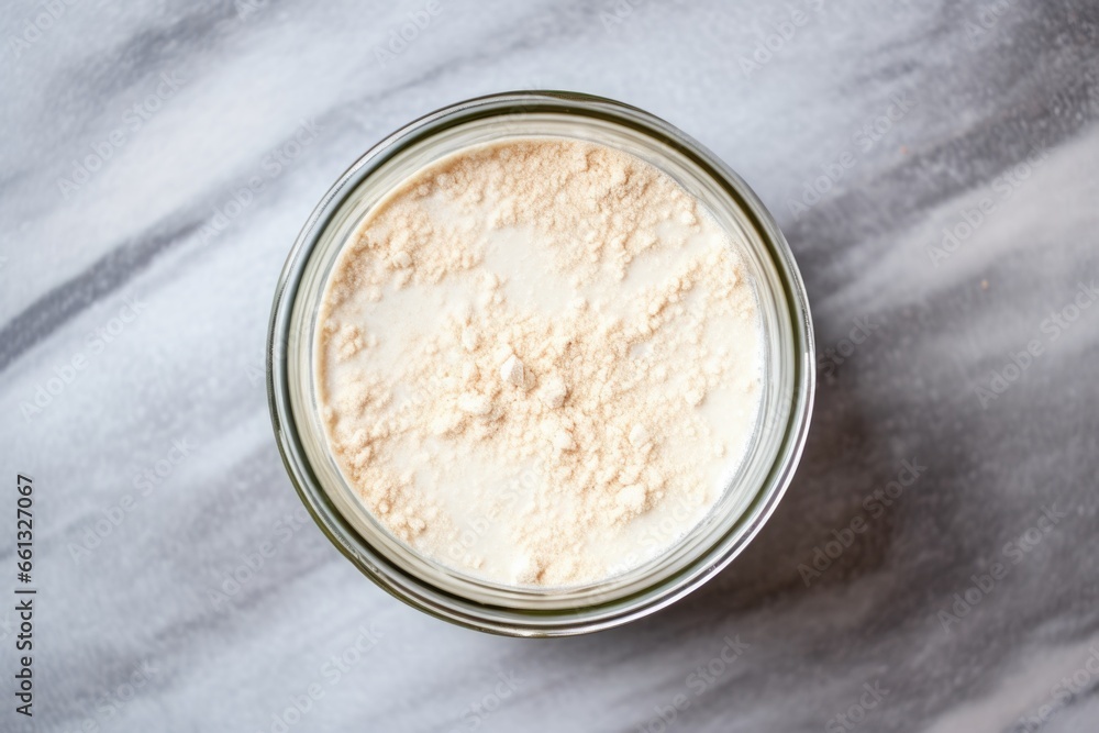 view from above of sourdough starter in a clear, glass jar view from above of sourdough starter in a clear, glass jar