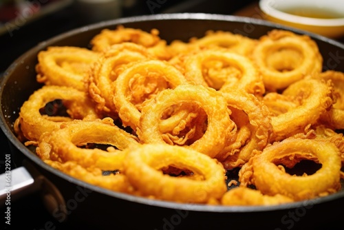 a close-up shot of fried onion rings in a pan