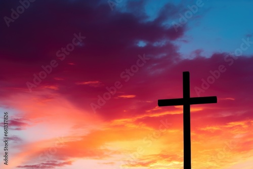 the silhouette of a cross against a colorful sunset sky