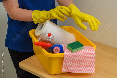 Kobieta sprzątaczka zakłada gumowe rękawice do sprzątania 