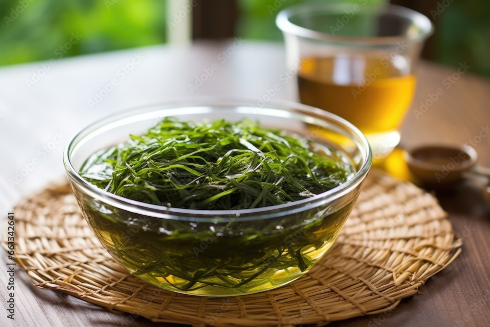 seaweed salad served in a clear glass bowl on a bamboo mat seaweed salad served in a clear glass bowl on a bamboo mat
