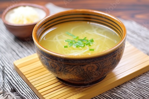 garlic detox soup in an oriental bowl, resting on a bamboo mat