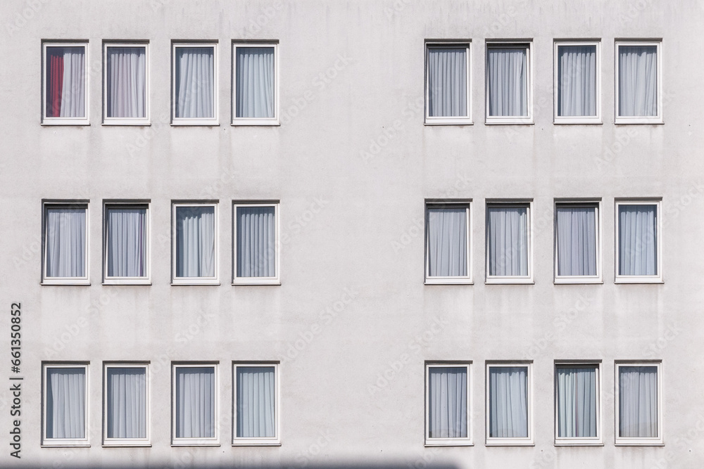 pattern of a white house wall with windows in geometrical order as symbol for apartment building