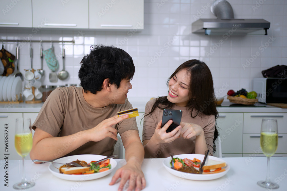 Young couple is shopping online in kitchen.