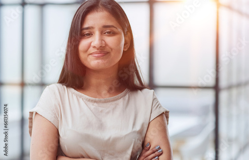portrait of a smiling business woman with her arms crossed against the backdrop of the office