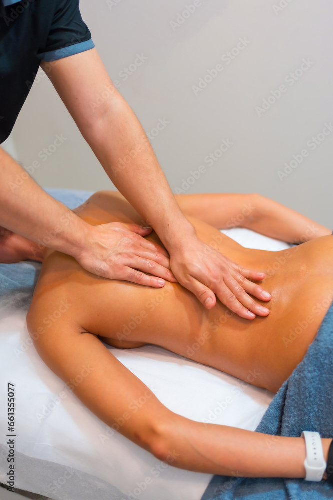 Physiotherapeutic massage to an unrecognizable woman lying on a stretcher on her back Physiotherapeutic massage to an unrecognizable woman lying on a stretcher on her back