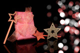 A beautiful pink gift with a bow and stars, on a black background