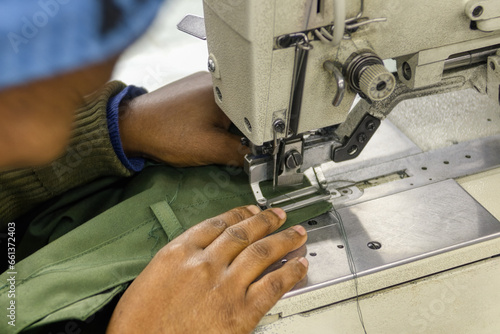 african woman entrepreneur in textile industry,  factory workers in the buttonhole machine working on workwear clothing