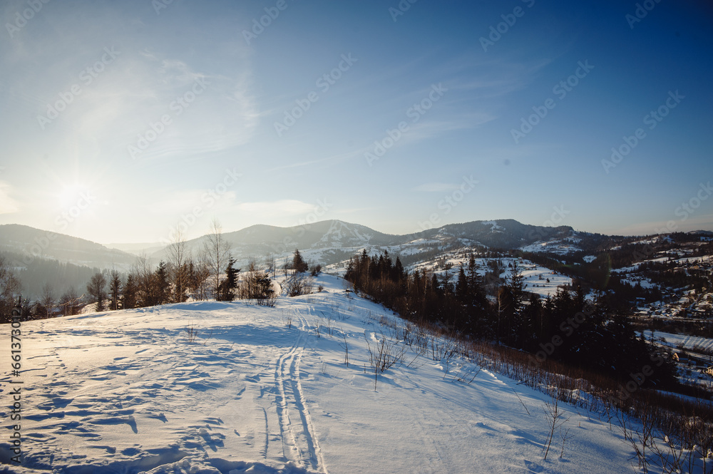 Scenic mountain nature landscape. Carpathian mountains covered with fresh snow. Mountain village. Place for text.
