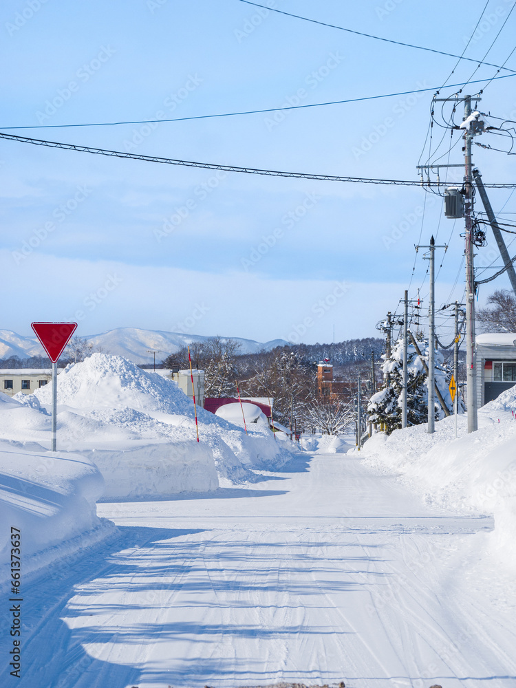 Intersection in a heavy snowfall area town on a sunny day (Niseko, Hokkaido, Japan)