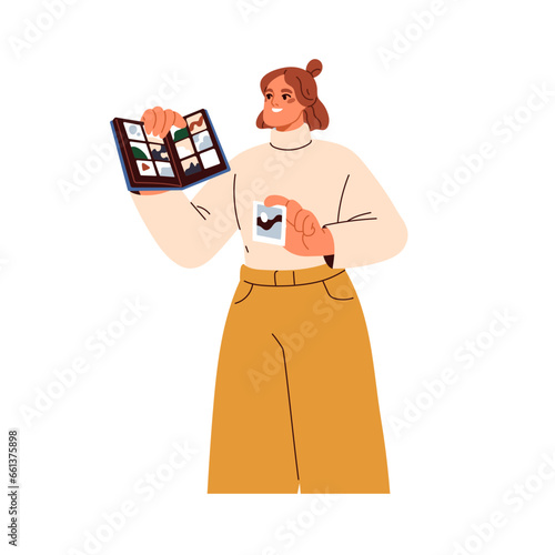 Photo album with photographs. Woman holding photoalbum, photobook in hands. G...