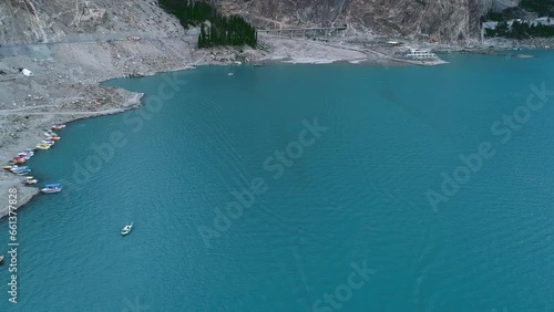 Drone flight over the Hunza valley, a long blue river below with boats and boats with tourists in summer photo