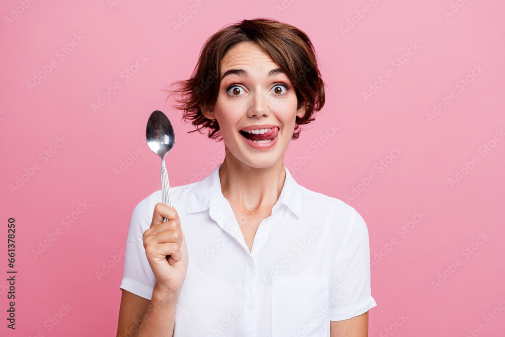 Portrait of funny young girl lick teeth want eat that delicious dessert holding silver spoon excited isolated on pink color background Portrait of funny young girl lick teeth want eat that delicious dessert holding silver spoon excited isolated on pink color background