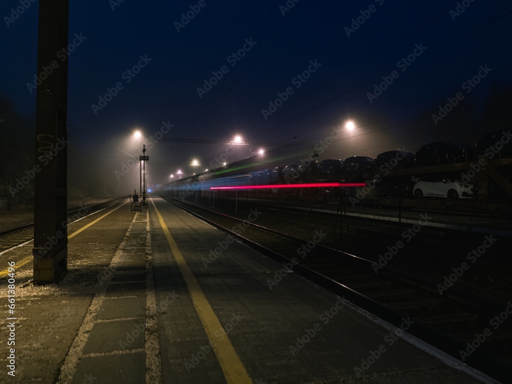 Empty railway station platform at night, long exposure with light trails