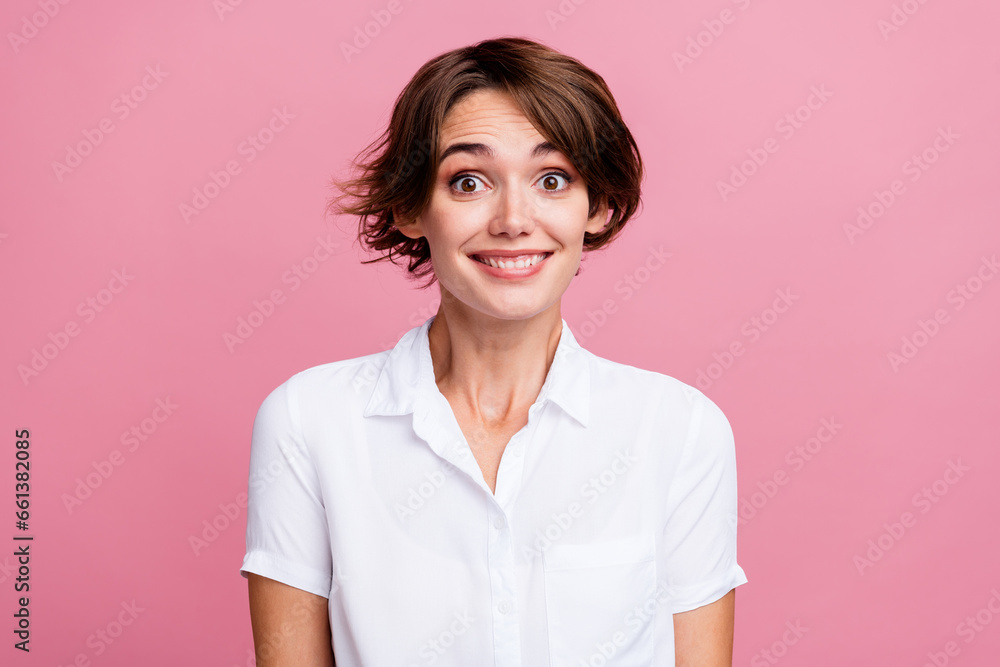 Portrait of lovely cheerful girl with short hairstyle wear stylish blouse astonished staring smiling isolated on pink color background Portrait of lovely cheerful girl with short hairstyle wear stylish blouse astonished staring smiling isolated on pink color background