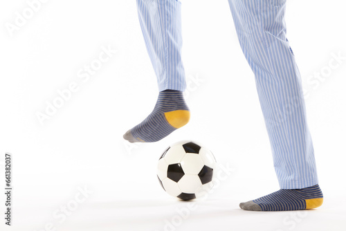 Young man in pajama playing football. Legs. Night wear