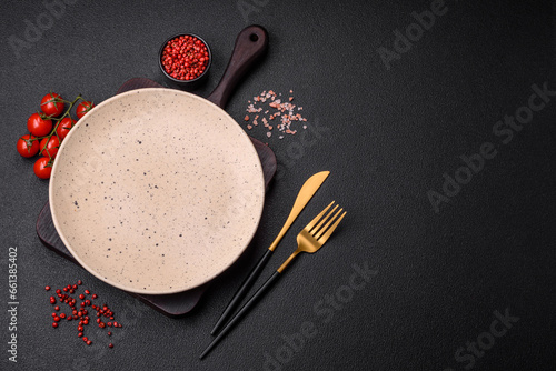 Tablou pe pânză Empty round ceramic plate on a dark textured background