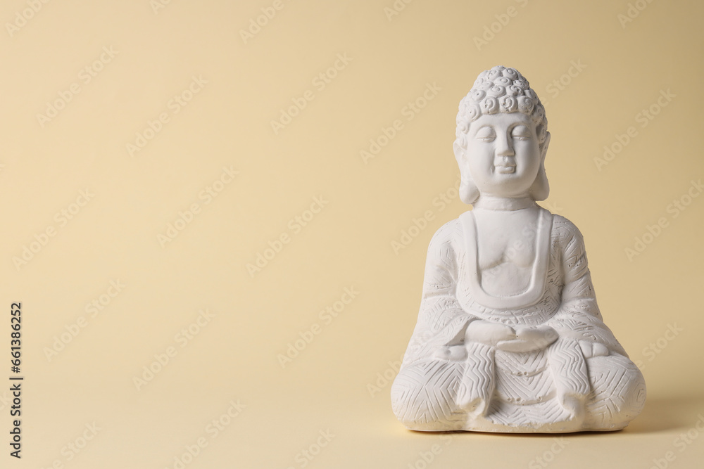 White Buddha statue on light beige background, space for text White Buddha statue on light beige background, space for text