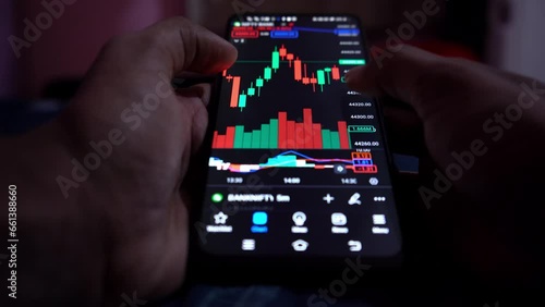 financial banker or investor analyzing stock market graph on smartphone  photo