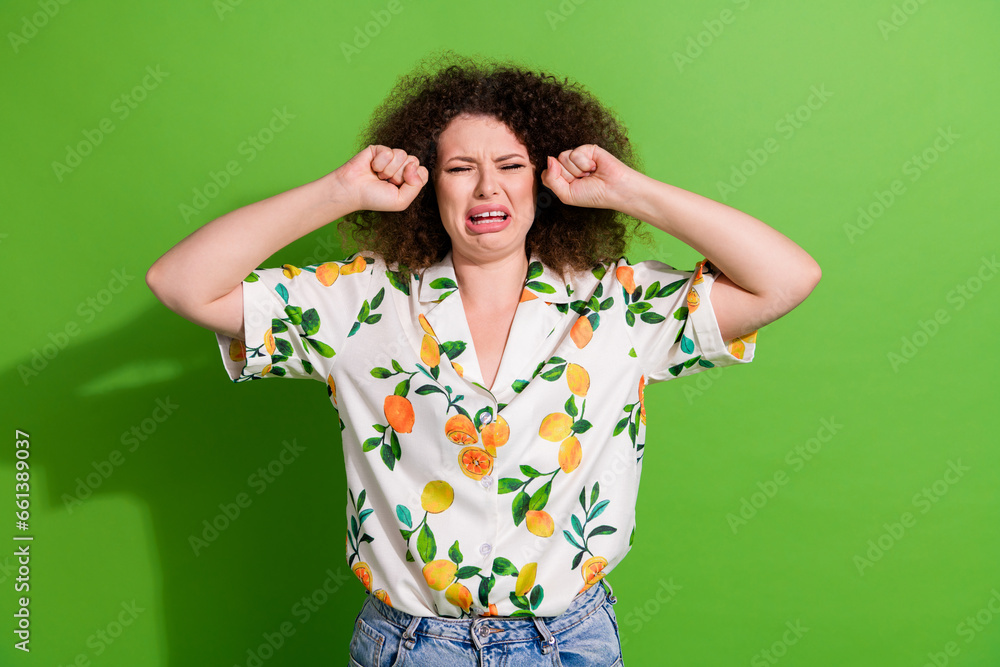 Portrait of unsatisfied desperate person arm fists wipe cry tears bad mood isolated on green color background Portrait of unsatisfied desperate person arm fists wipe cry tears bad mood isolated on green color background