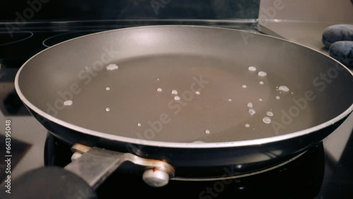 Water splashed onto teflon pan, evaporating fast. Closeup, static. pfas health concerns