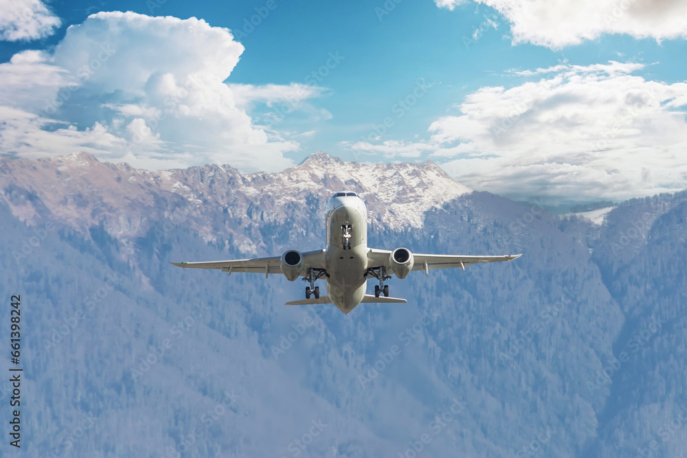 Passenger jet airliner takes off rapidly over a mountain range against the background with a clouds blue sky Passenger jet airliner takes off rapidly over a mountain range against the background with a clouds blue sky