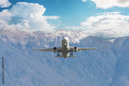 Passenger jet airliner takes off rapidly over a mountain range against the background with a clouds blue sky
