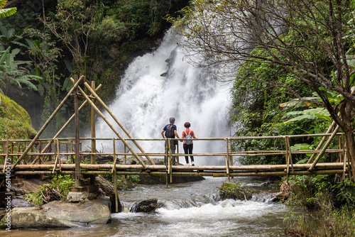 Couple seniors are walking on tropical forest trail in the outdoor recreation activities.