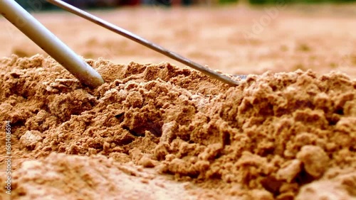 Soft sand being raked ready for the next beach tennis competition, slo-mo